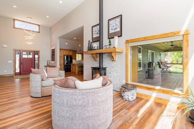 27667 Bay Shore Dr NW, Isanti, MN 55040 - living area with a towering ceiling, a wood stove, wood finished floors, baseboards, and recessed lighting