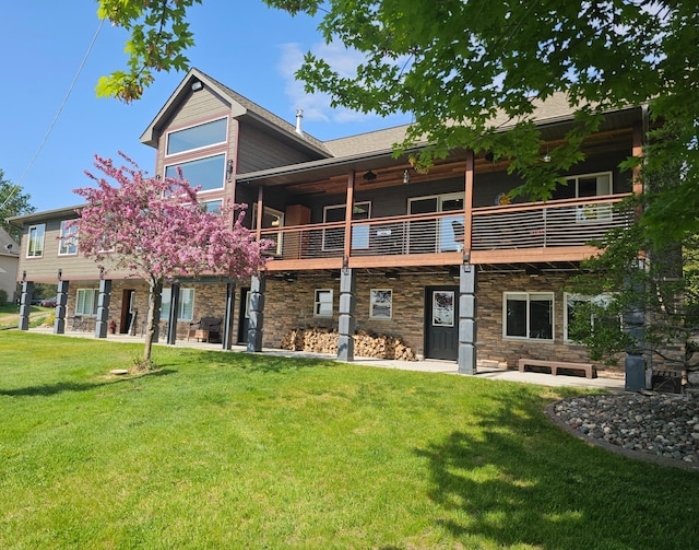 27667 Bay Shore Dr NW, Isanti, MN 55040 - rear view of property with stone siding, a lawn, a balcony, and a patio