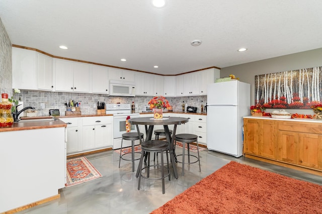 27667 Bay Shore Dr NW, Isanti, MN 55040 - kitchen featuring white appliances, backsplash, white cabinets, finished concrete floors, and a sink