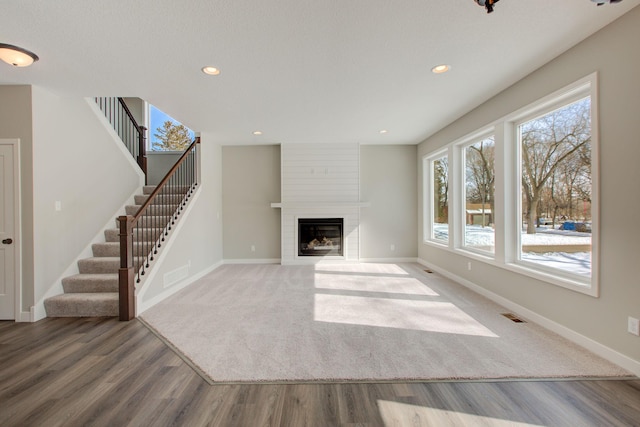 8683 Peony Ln N, Maple Grove, MN 55311 - unfurnished living room with baseboards, stairs, wood finished floors, a fireplace, and recessed lighting