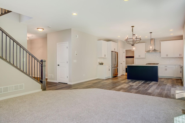 8683 Peony Ln N, Maple Grove, MN 55311 - kitchen with appliances with stainless steel finishes, wall chimney exhaust hood, a chandelier, a kitchen island, and white cabinets