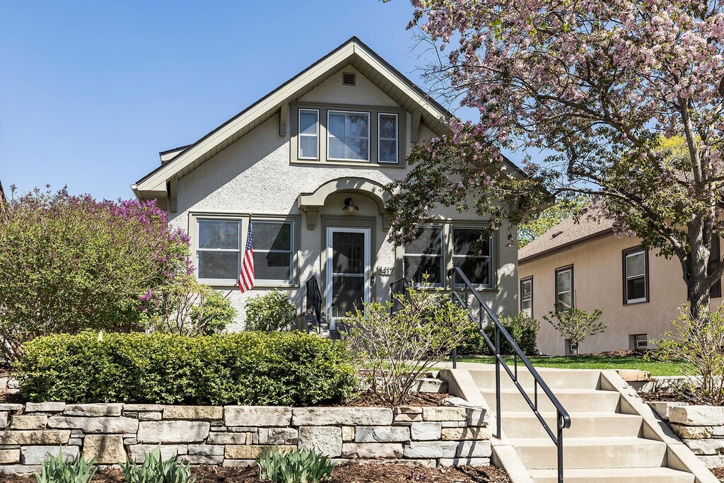 bungalow-style house featuring stucco siding and stairs