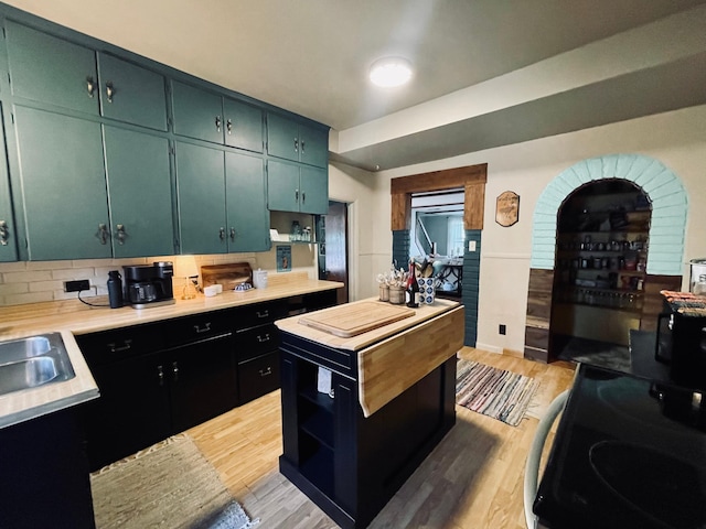 506 2nd St S, Tower, MN 55790 - kitchen with light countertops, light wood-style flooring, range with electric cooktop, open shelves, and decorative backsplash