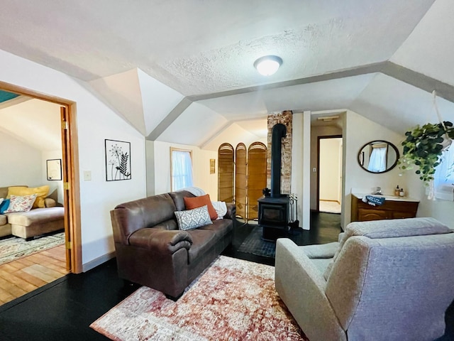506 2nd St S, Tower, MN 55790 - living area featuring vaulted ceiling, a wood stove, a textured ceiling, wood finished floors, and baseboards