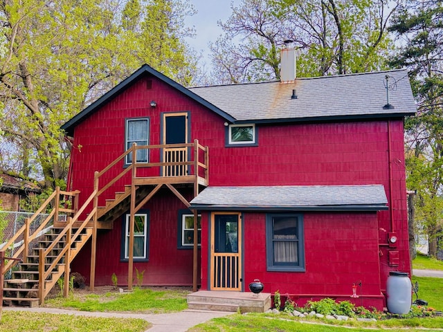 506 2nd St S, Tower, MN 55790 - view of front of property featuring roof with shingles, stairs, a chimney, and a front lawn