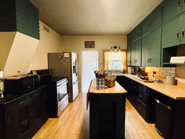 506 2nd St S, Tower, MN 55790 - kitchen with appliances with stainless steel finishes, light wood-style floors, light countertops, and a center island