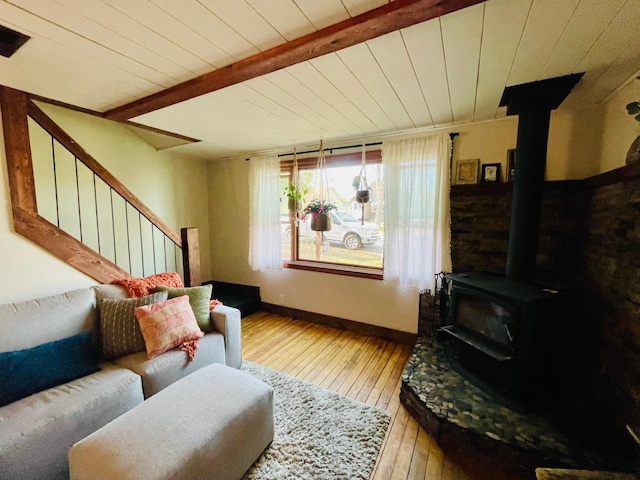 506 2nd St S, Tower, MN 55790 - living area with a wood stove, wood-type flooring, stairs, wooden ceiling with exposed beams, and baseboards