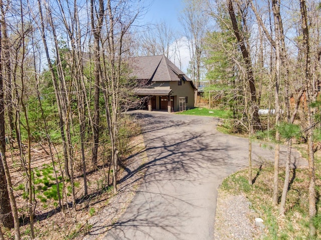 view of front of home with asphalt driveway and roof with shingles