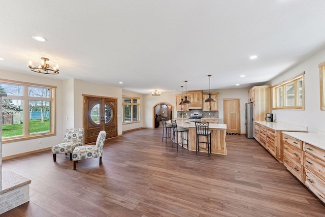 living room with recessed lighting, a chandelier, baseboards, and wood finished floors
