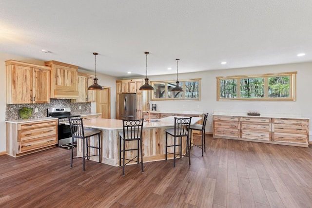 kitchen with stainless steel appliances, a sink, light brown cabinetry, dark wood-type flooring, and recessed lighting