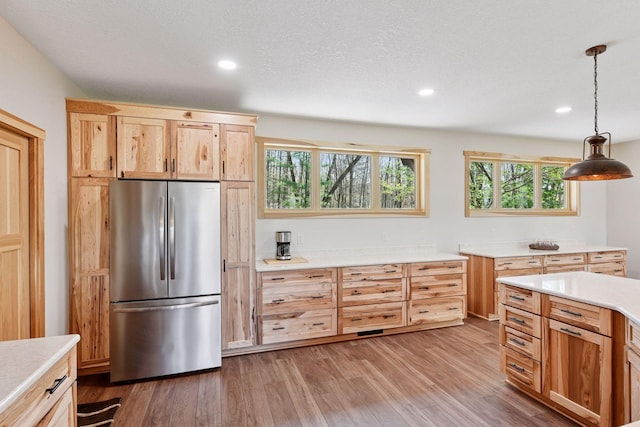 kitchen with freestanding refrigerator, light countertops, wood finished floors, plenty of natural light, and recessed lighting