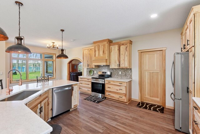 kitchen with appliances with stainless steel finishes, a sink, light brown cabinets, light countertops, and recessed lighting