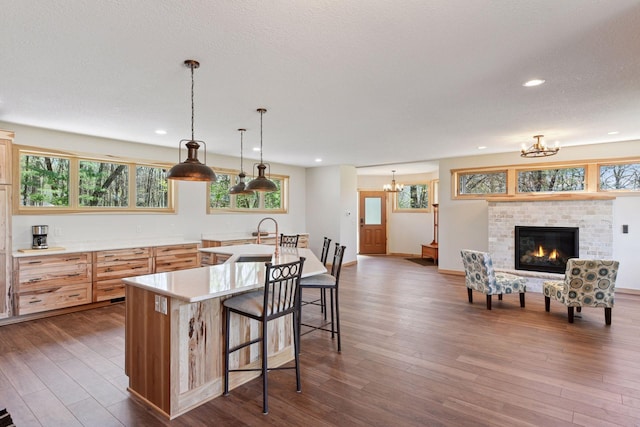 kitchen featuring a chandelier, light countertops, recessed lighting, dark wood-style floors, and a breakfast bar area