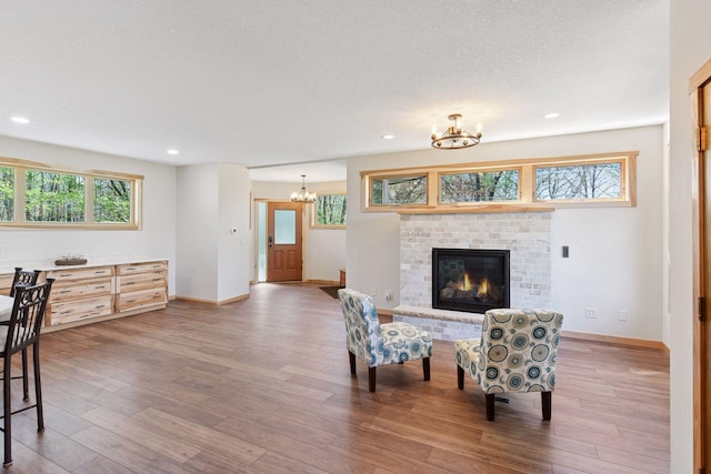 living area with a chandelier, wood finished floors, healthy amount of natural light, and recessed lighting