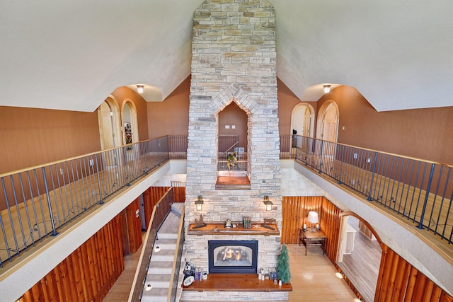 hall featuring wood finished floors and high vaulted ceiling
