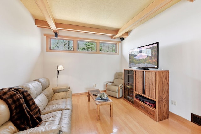 living room with beamed ceiling and wood finished floors
