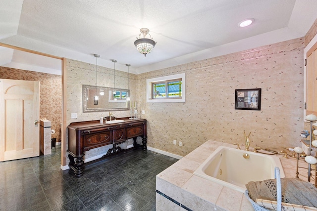 bathroom with baseboards, a tub with jets, and vanity