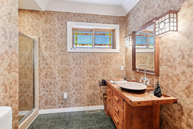 bathroom with a stall shower, baseboards, toilet, and vanity