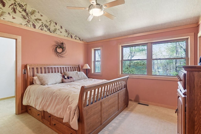 bedroom with light colored carpet, lofted ceiling, a textured ceiling, ceiling fan, and baseboards