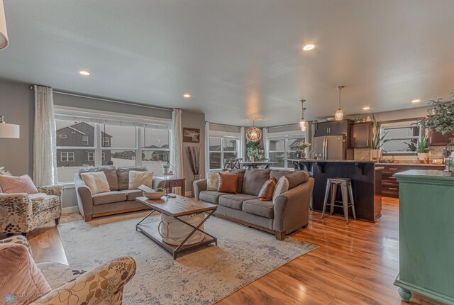 living area featuring light wood-style flooring and recessed lighting
