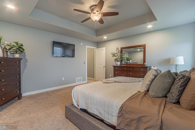bedroom featuring baseboards, recessed lighting, carpet floors, a tray ceiling, and ceiling fan
