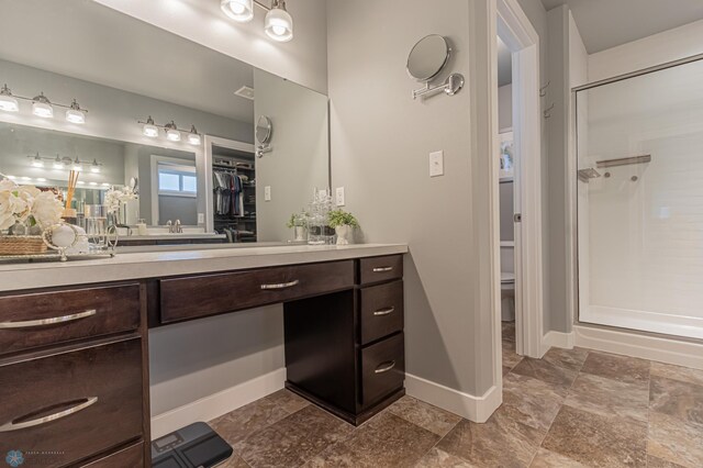 bathroom featuring a walk in shower, vanity, and baseboards
