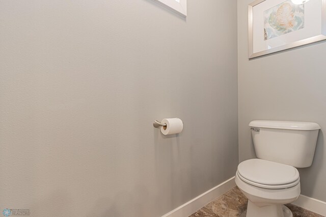bathroom featuring baseboards and toilet