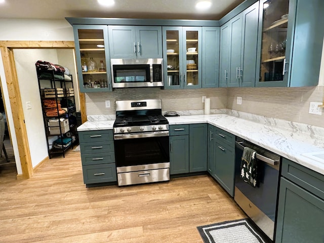 23479 State 200, Itasca Twp, MN 56676 - kitchen featuring appliances with stainless steel finishes, light wood finished floors, glass insert cabinets, light stone counters, and recessed lighting