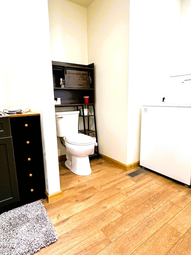 23479 State 200, Itasca Twp, MN 56676 - bathroom featuring hardwood / wood-style floors, toilet, and baseboards