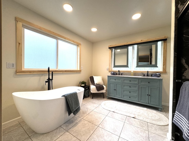 23479 State 200, Itasca Twp, MN 56676 - bathroom featuring double vanity, a soaking tub, recessed lighting, tile patterned flooring, and baseboards