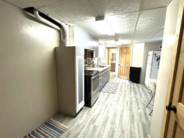23479 State 200, Itasca Twp, MN 56676 - kitchen with stainless steel electric range oven, a sink, light wood-style floors, light countertops, and a paneled ceiling