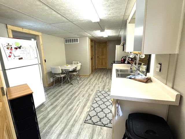 23479 State 200, Itasca Twp, MN 56676 - kitchen featuring freestanding refrigerator, light wood finished floors, a sink, light countertops, and baseboards