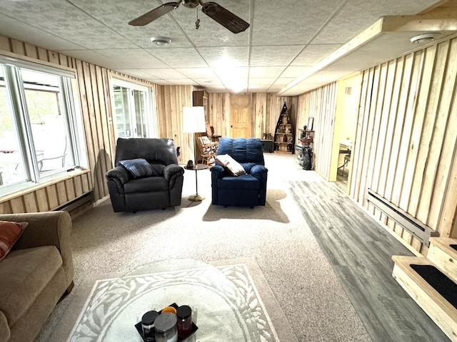 23479 State 200, Itasca Twp, MN 56676 - living area featuring wooden walls, a baseboard radiator, carpet, and a ceiling fan