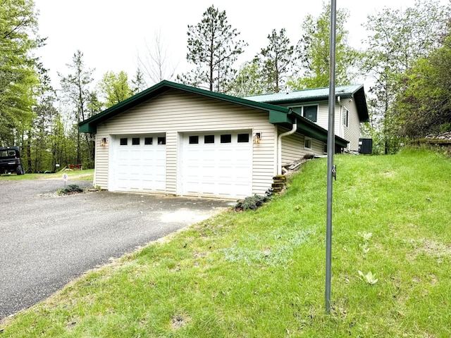 23479 State 200, Itasca Twp, MN 56676 - garage featuring central AC unit and asphalt driveway