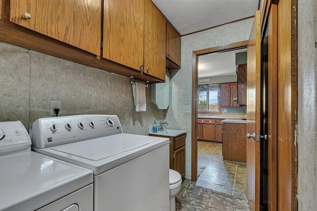 laundry room featuring washer and clothes dryer and a textured ceiling