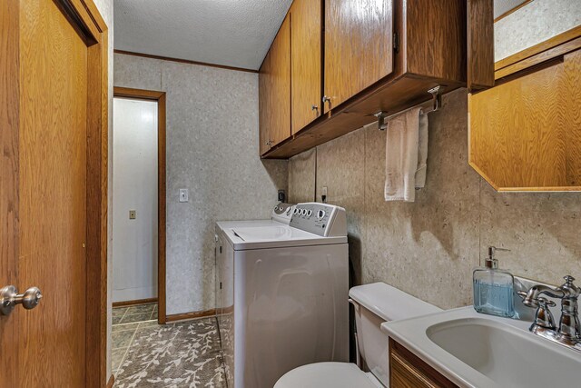 half bathroom with washing machine and clothes dryer, toilet, a textured ceiling, vanity, and tile patterned flooring