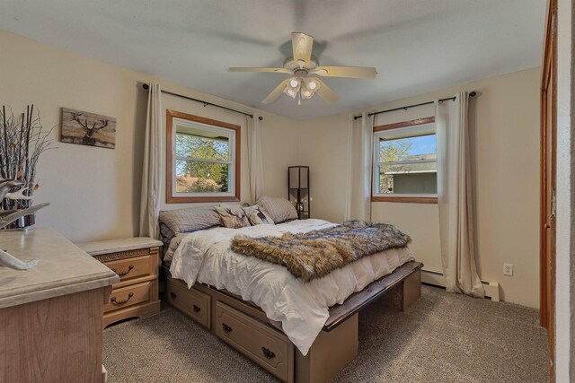 carpeted bedroom featuring a baseboard radiator, multiple windows, and ceiling fan
