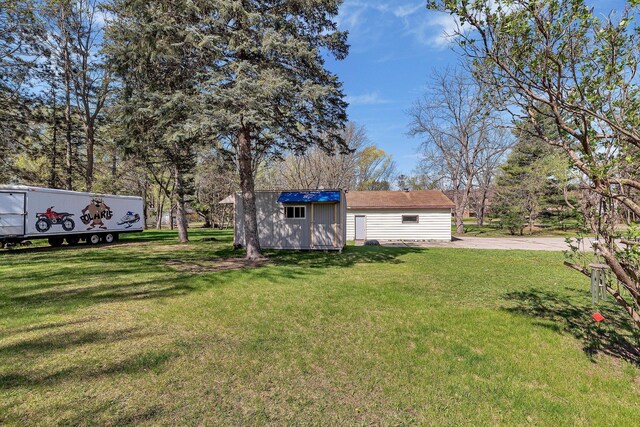 view of grassy yard featuring an outdoor structure and a storage unit