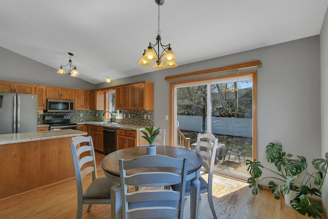 1908 5th St N, Sartell, MN 56377 - kitchen featuring stainless steel appliances, a chandelier, a sink, tasteful backsplash, and light wood-type flooring