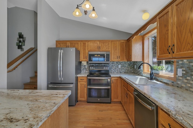 1908 5th St N, Sartell, MN 56377 - kitchen with appliances with stainless steel finishes, a sink, vaulted ceiling, light wood-type flooring, and backsplash