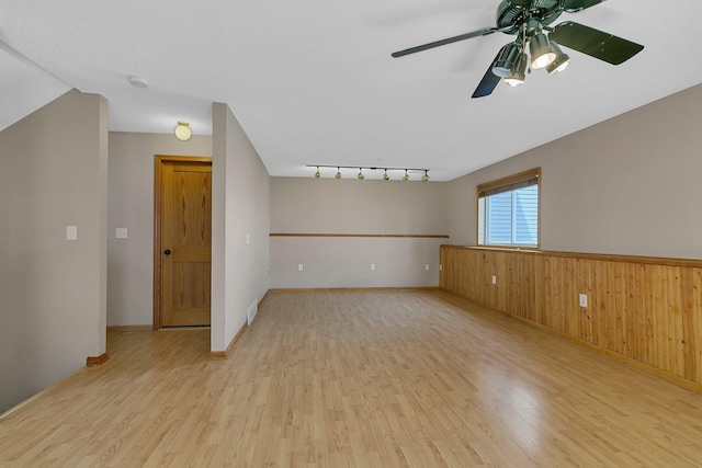 1908 5th St N, Sartell, MN 56377 - unfurnished room with wood finished floors, a ceiling fan, a wainscoted wall, wooden walls, and a smoke detector