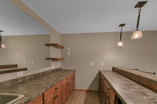 1908 5th St N, Sartell, MN 56377 - kitchen with open shelves, dark countertops, a textured ceiling, brown cabinets, and light wood-style flooring