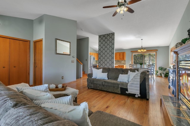 1908 5th St N, Sartell, MN 56377 - living room featuring vaulted ceiling, a ceiling fan, light wood-style floors, and a chandelier