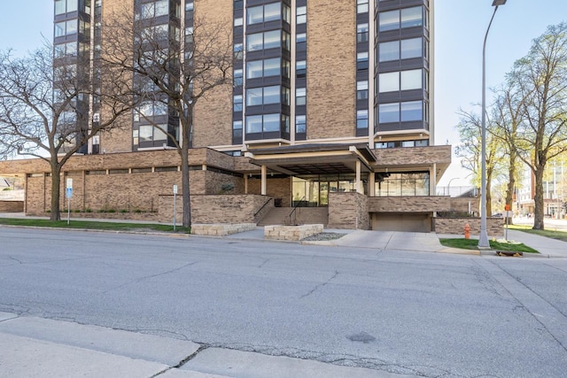 view of apartment building / complex featuring a garage and driveway
