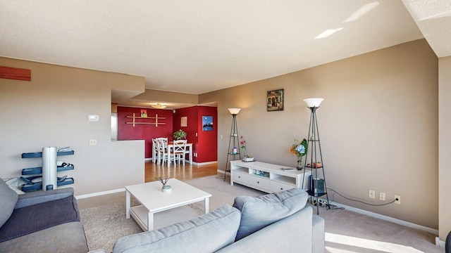 living room featuring light colored carpet and baseboards