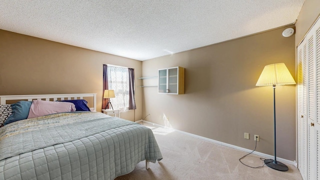 bedroom with carpet, a textured ceiling, and baseboards
