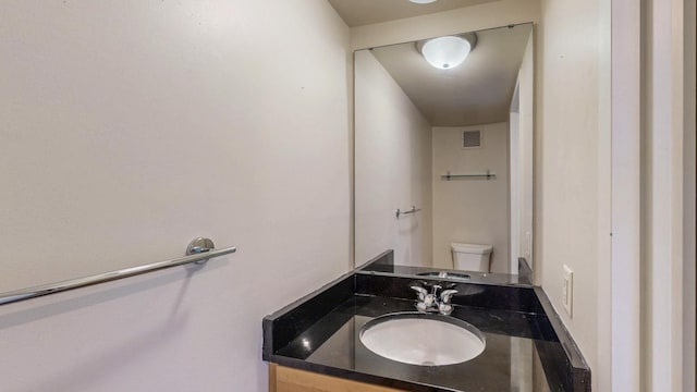 half bathroom with vanity and toilet