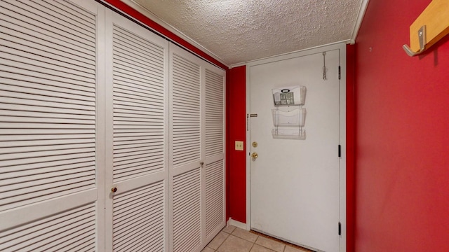 hallway featuring a textured ceiling and light tile patterned flooring