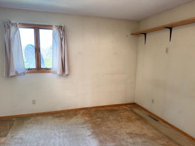 carpeted spare room featuring baseboards