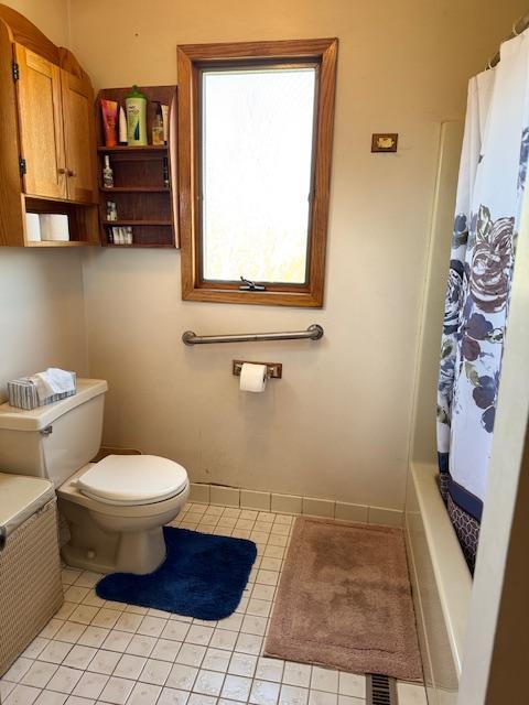 full bathroom featuring toilet and tile patterned floors
